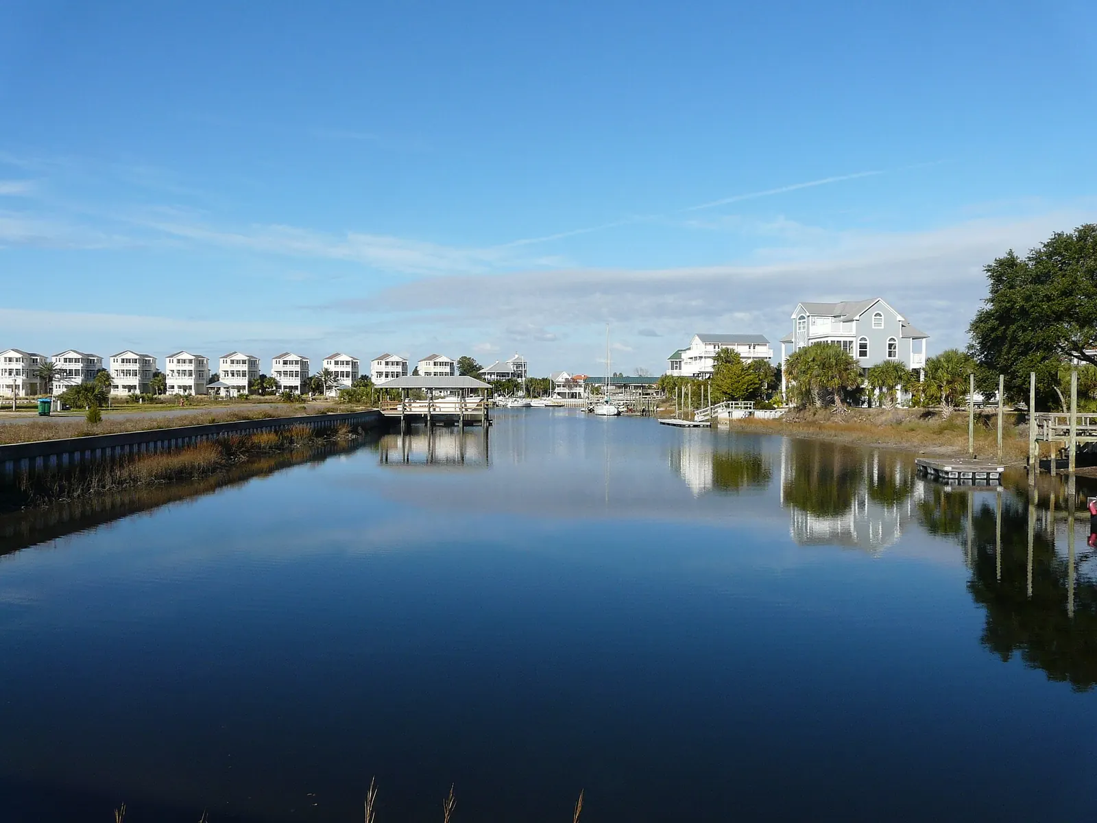 Capped sheet-pile bulkhead along a calm residential canal with docks in Shell Point, Florida